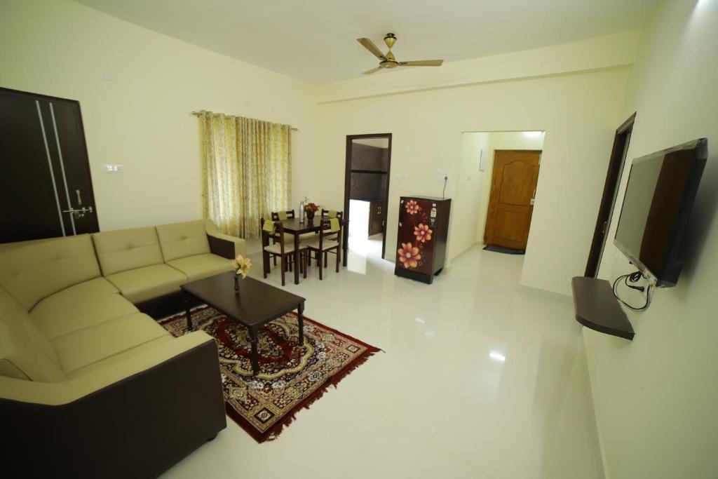een woonkamer met een bank en een tafel bij Taj homes stay in Tirupati