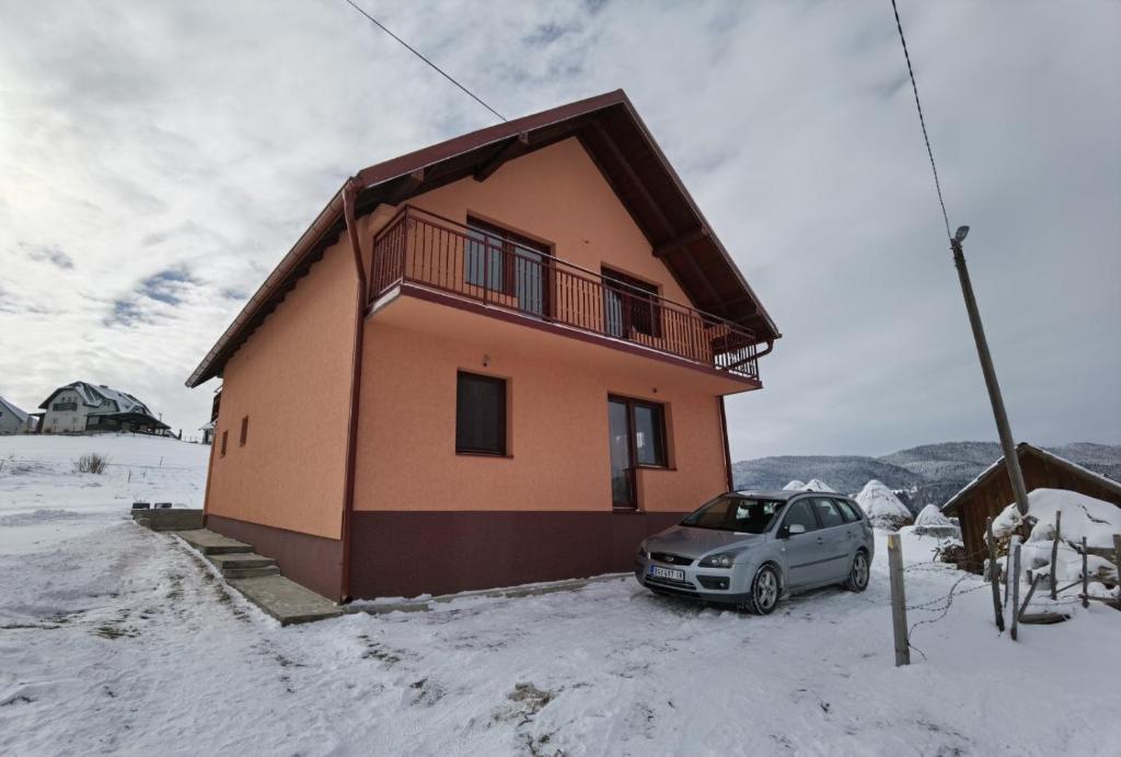 a car parked in front of a house in the snow at Apartman Bambi Zlatar in Nova Varoš