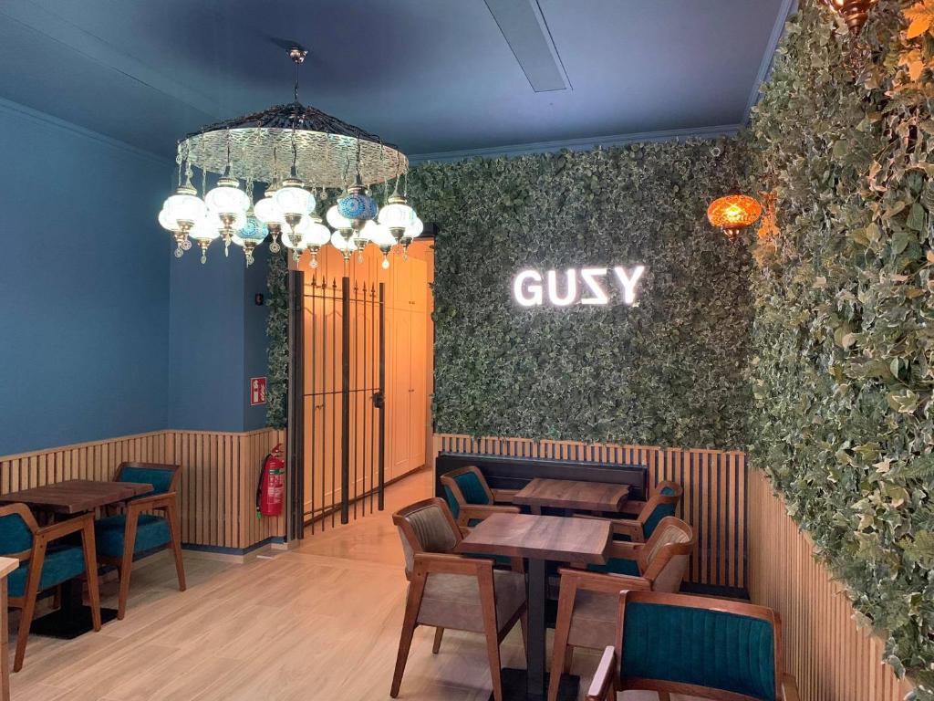 a restaurant with tables and chairs and a guilty sign on the wall at Hotel Guzy in Lier