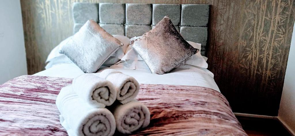 a bed with towels and pillows on it at Brookview 2BR Flat Oxford City Centre Free Parking in Oxford