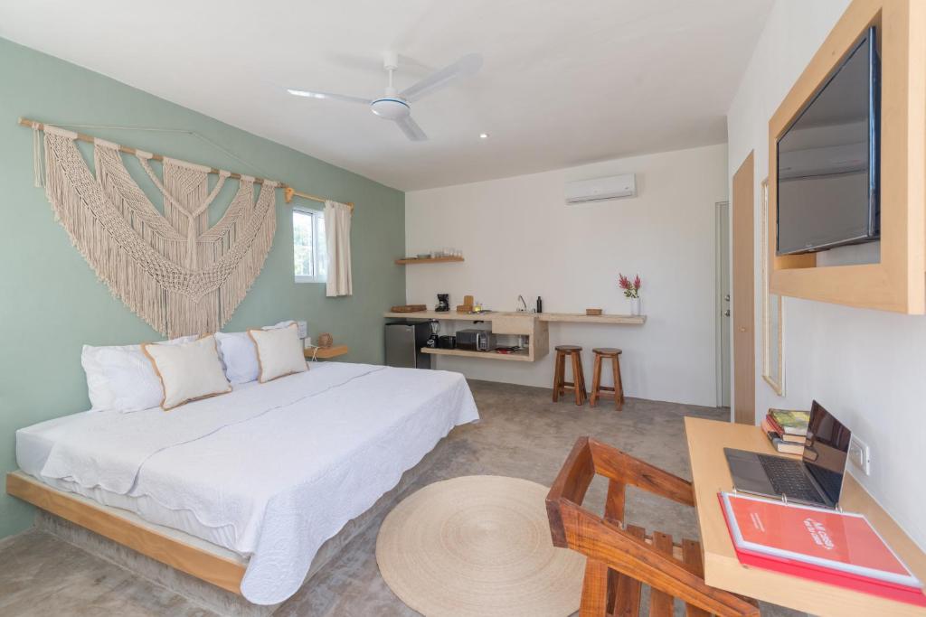 um quarto com uma cama, uma secretária e uma televisão em Casa Neem em Cancún