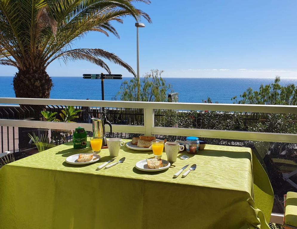 a table with food on it with the ocean in the background at Apartamento Jumilla Vista Mar 22 in Playa del Ingles