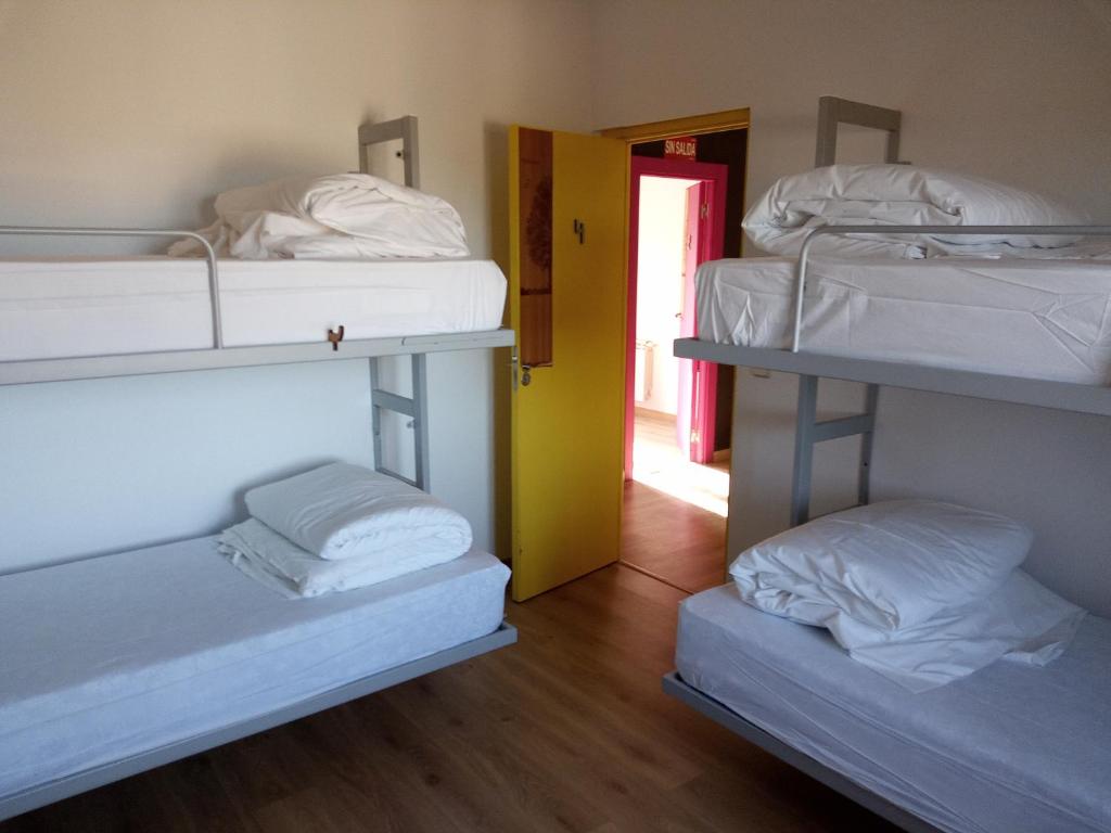 a room with three bunk beds and a hallway at Albergue Fresno de Cantespino - La Tormenta in Fresno de Cantespino