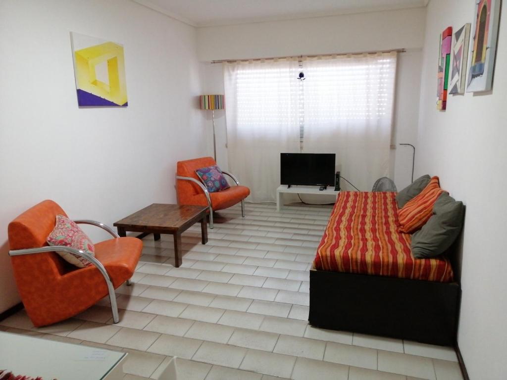 a living room with a couch and chairs and a tv at Por fin un lugar familiar in Mar del Plata