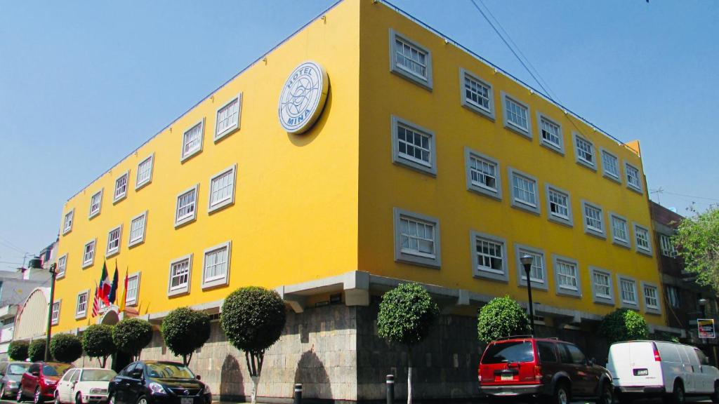 un edificio amarillo con un reloj a un lado en Hotel Mina, en Ciudad de México