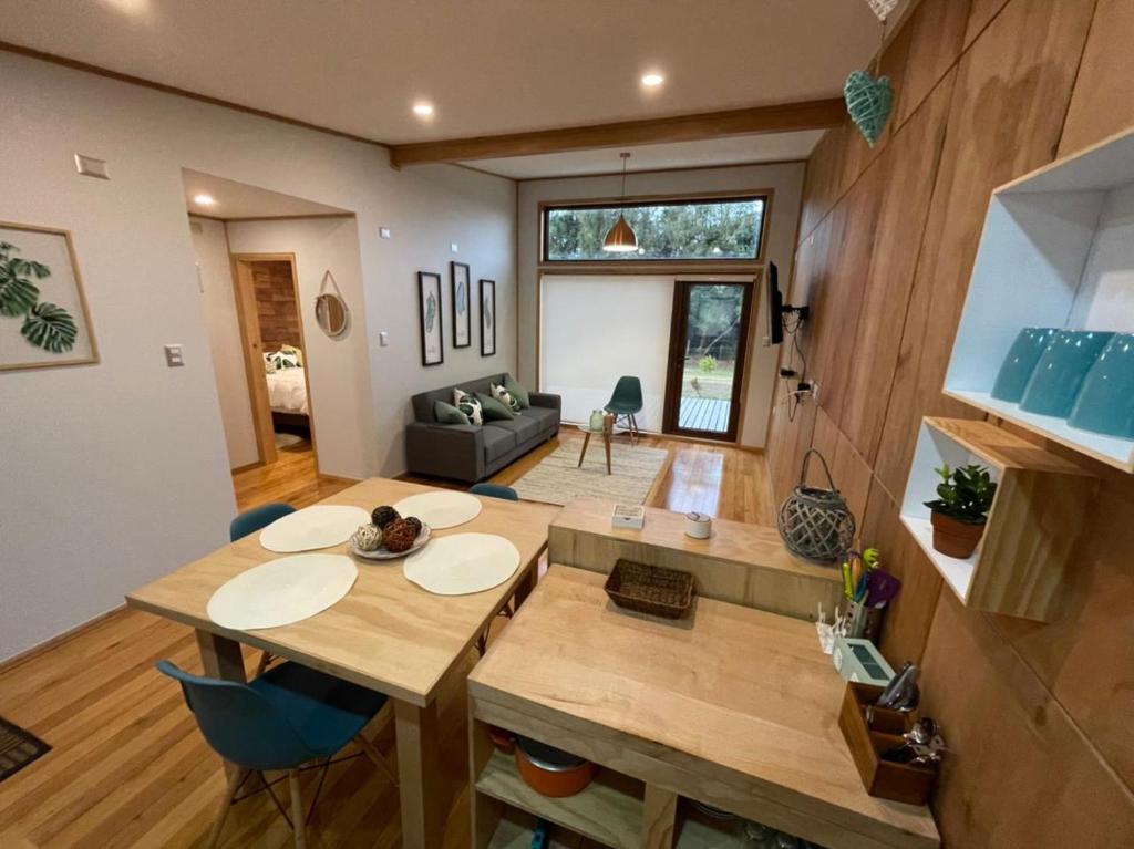 a dining room and living room with a table and chairs at Cabañas Arrayanes de Huillinco en Chiloé in Chonchi