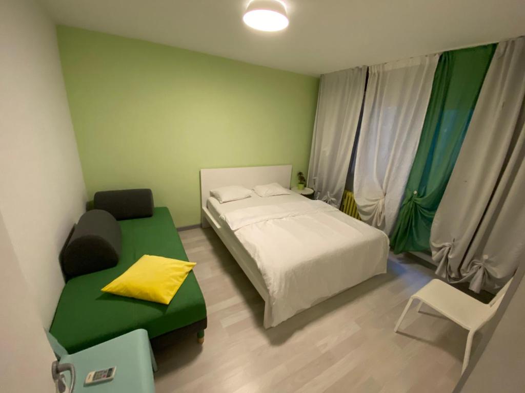 een kleine slaapkamer met een bed en een bank bij VICTORIEI by GREEN APARTMENTS in Boekarest