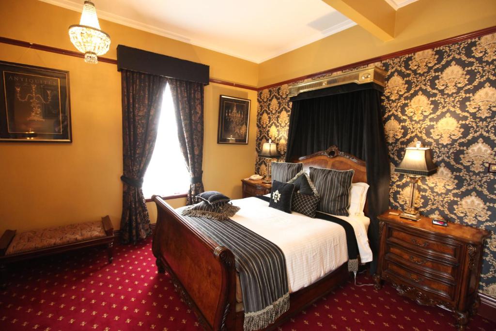 a bedroom with a large bed and a window at The Grand On Macfie in Devonport