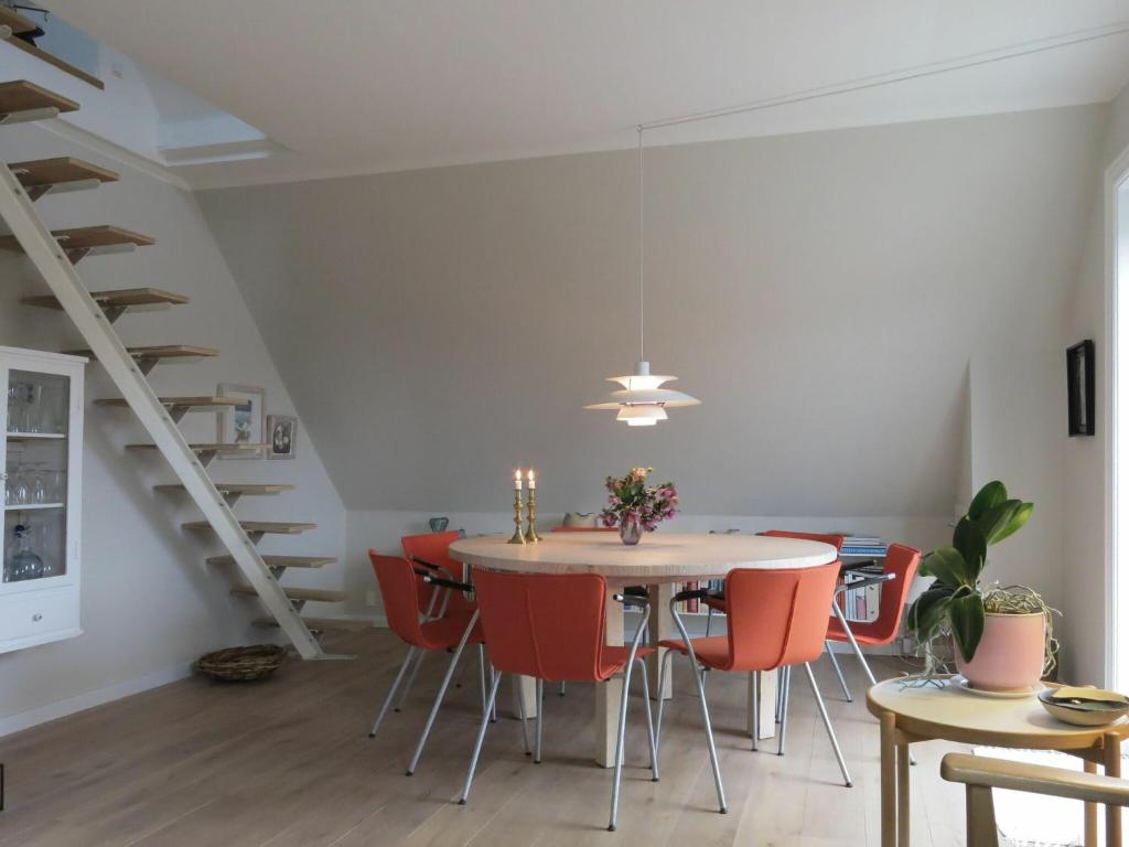 コペンハーゲンにあるApartmentInCopenhagen Apartment 1240のダイニングルーム(テーブル、赤い椅子付)