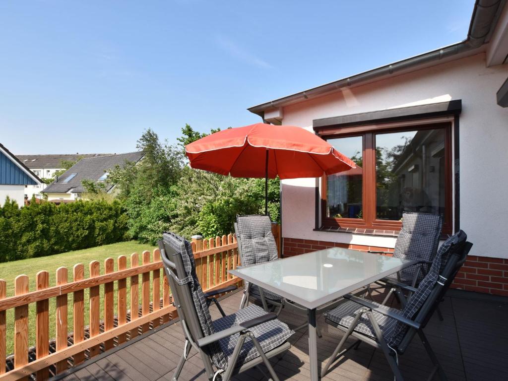 a table and chairs with an umbrella on a balcony at Cozy Apartment in Klutz near Sea in Klütz