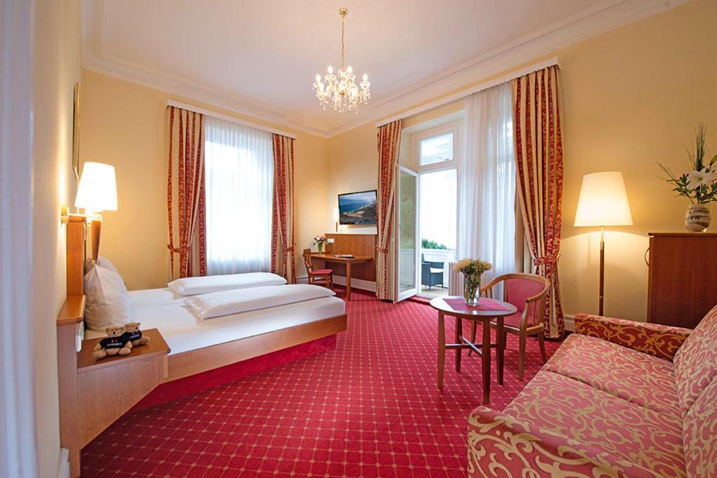 una camera d'albergo con letto e divano di Hotel Schweizer Hof - Superior a Baden-Baden