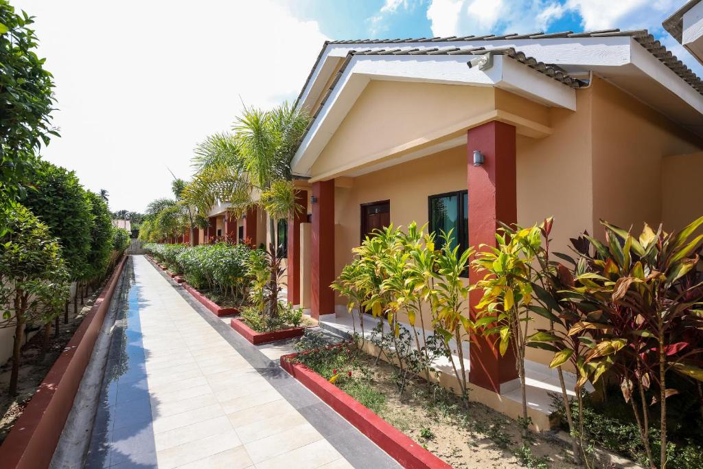 a house with palm trees on the side of it at Nahdhoh Langkawi Resort in Pantai Cenang