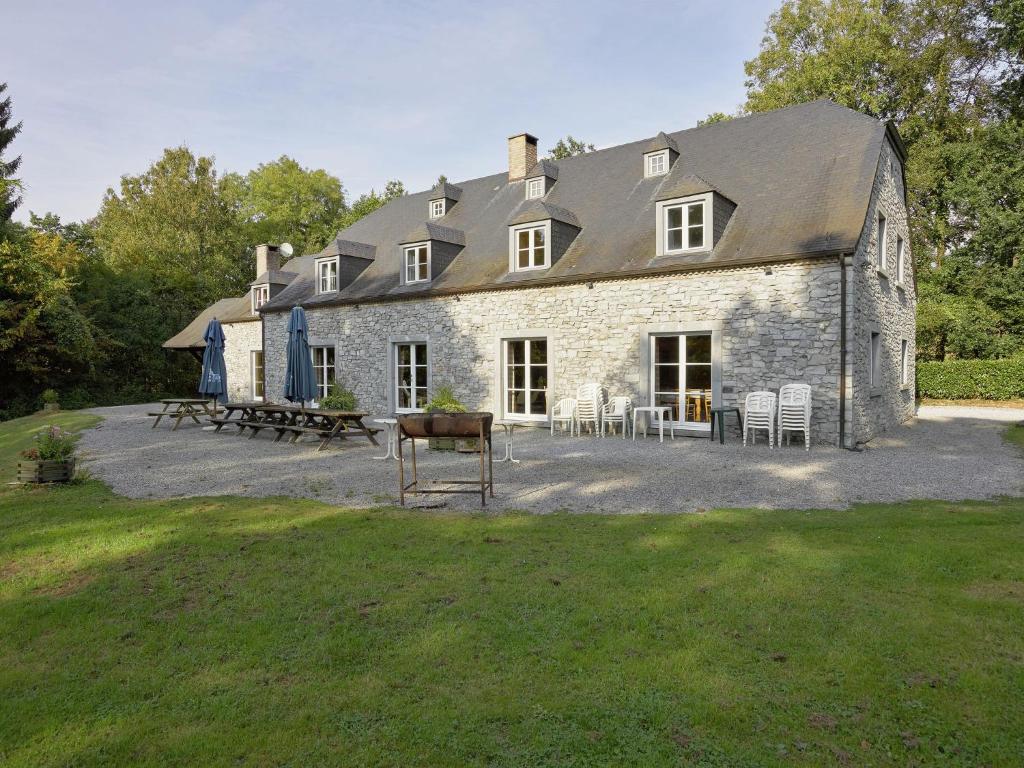 a large stone house with a picnic table and chairs at Spacious Holiday Home with Terrace in Anhee Belgium in Sosoye