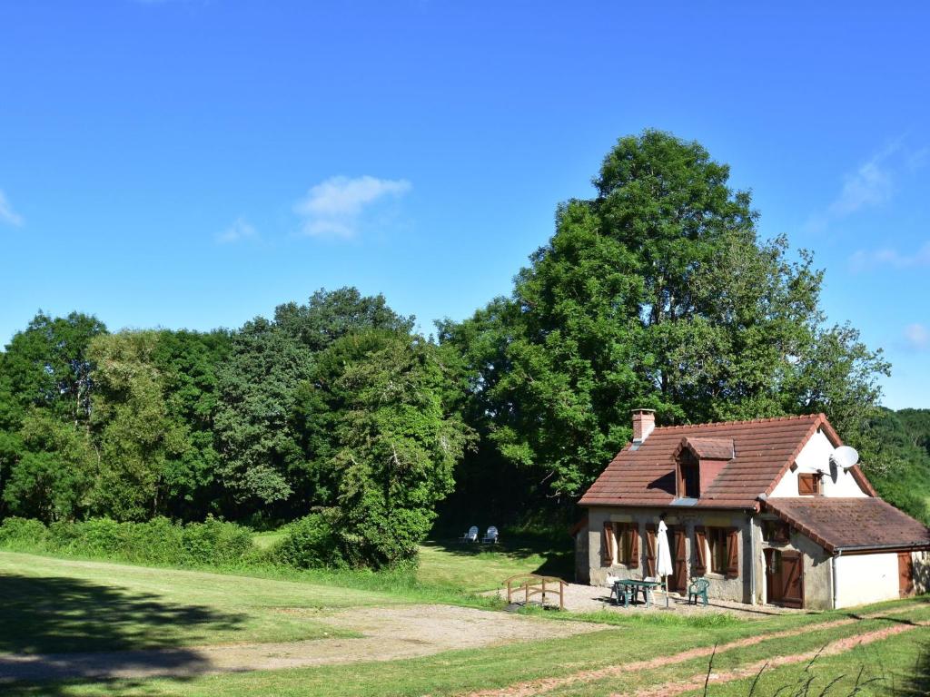 una casa vieja en un campo con árboles en Pretty holiday home with garden near forest, en Isenay