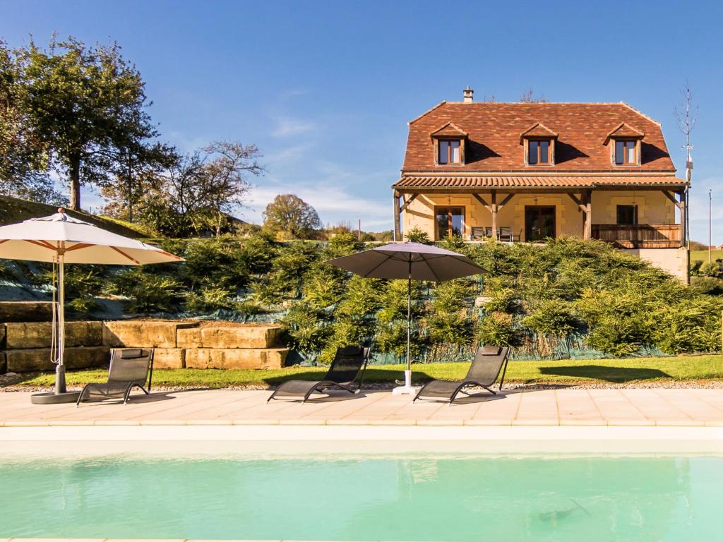 2 sedie e ombrelloni accanto alla piscina di Luxury villa with pool on the edge of Montignac a Montignac