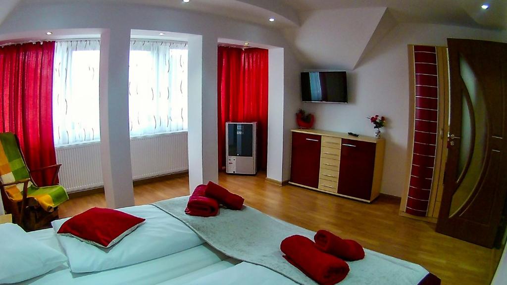 um quarto com uma cama grande com almofadas vermelhas em Mary Apartment em Sibiu