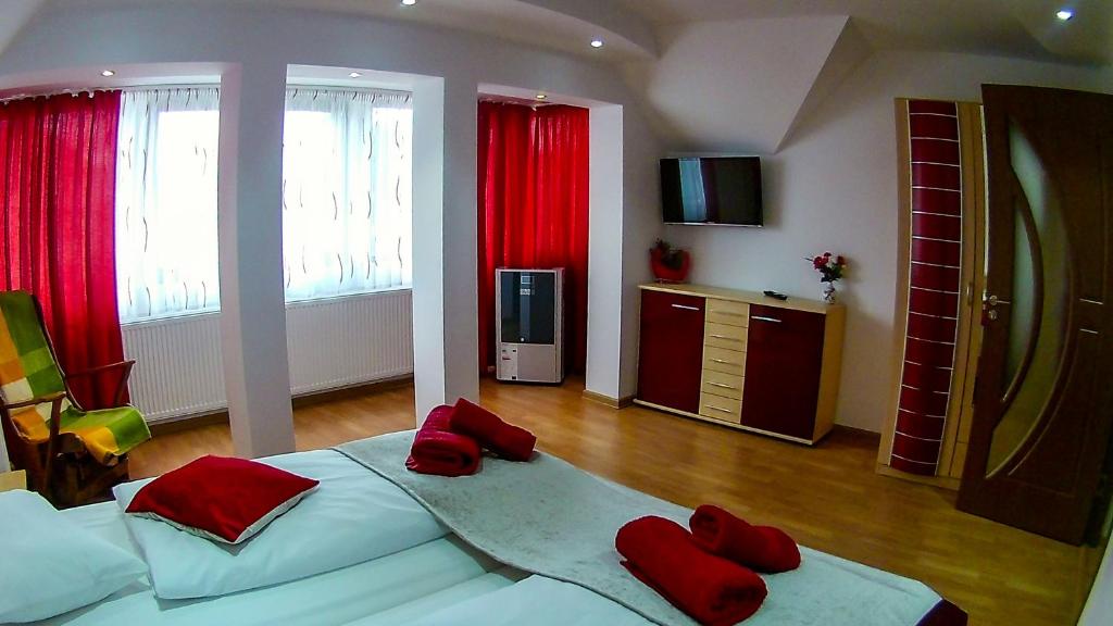 una camera da letto con un grande letto con cuscini rossi di Mary Apartment a Sibiu