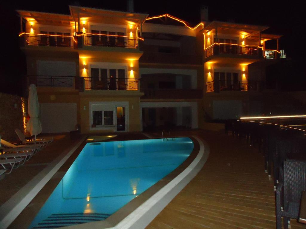 a swimming pool in front of a building at night at Agrabeli Apartments in Límni