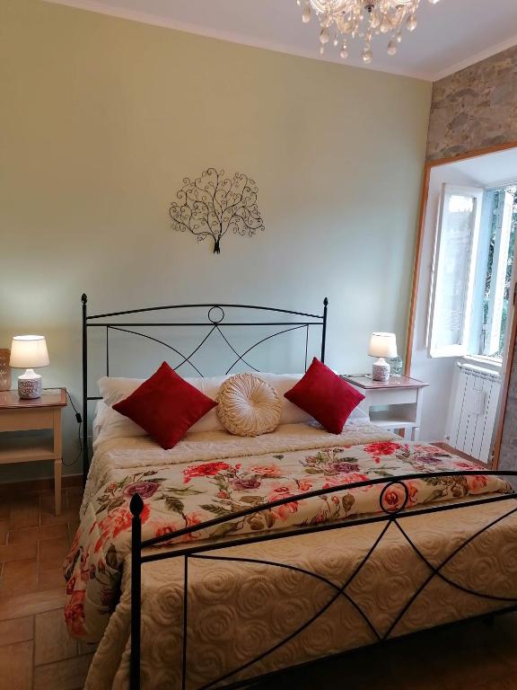 sypialnia z dużym łóżkiem z czerwonymi poduszkami w obiekcie La Maisonette del Borgo w mieście Ronciglione