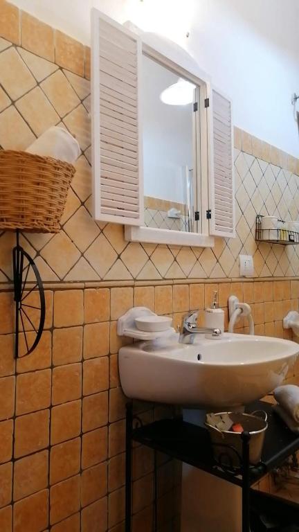łazienka z umywalką i lustrem w obiekcie La Maisonette del Borgo w mieście Ronciglione
