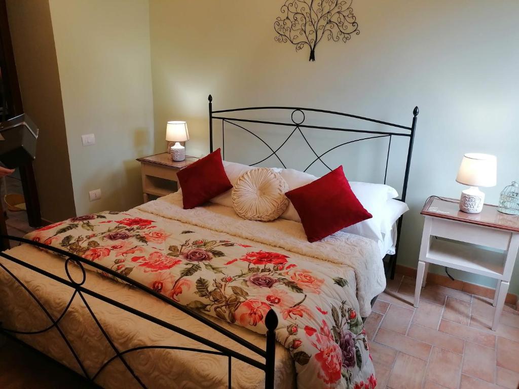 sypialnia z łóżkiem z czerwonymi poduszkami w obiekcie La Maisonette del Borgo w mieście Ronciglione