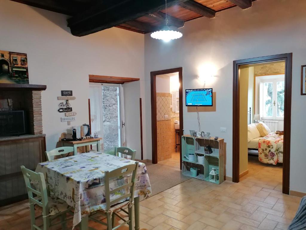 jadalnia ze stołem i telewizorem w pokoju w obiekcie La Maisonette del Borgo w mieście Ronciglione