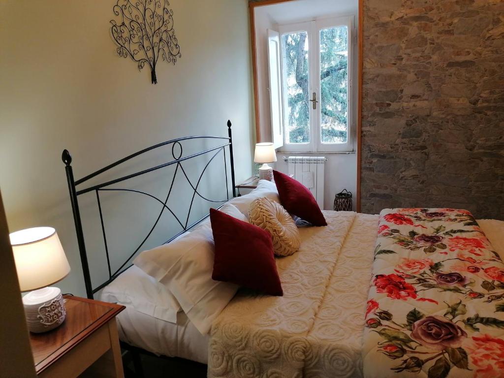 sypialnia z łóżkiem z czerwonymi poduszkami w obiekcie La Maisonette del Borgo w mieście Ronciglione