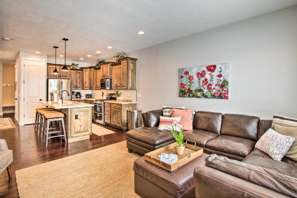 sala de estar con sofá y cocina en Edgewater Townhome about 7 Mi to Snowbasin Resort, en Huntsville