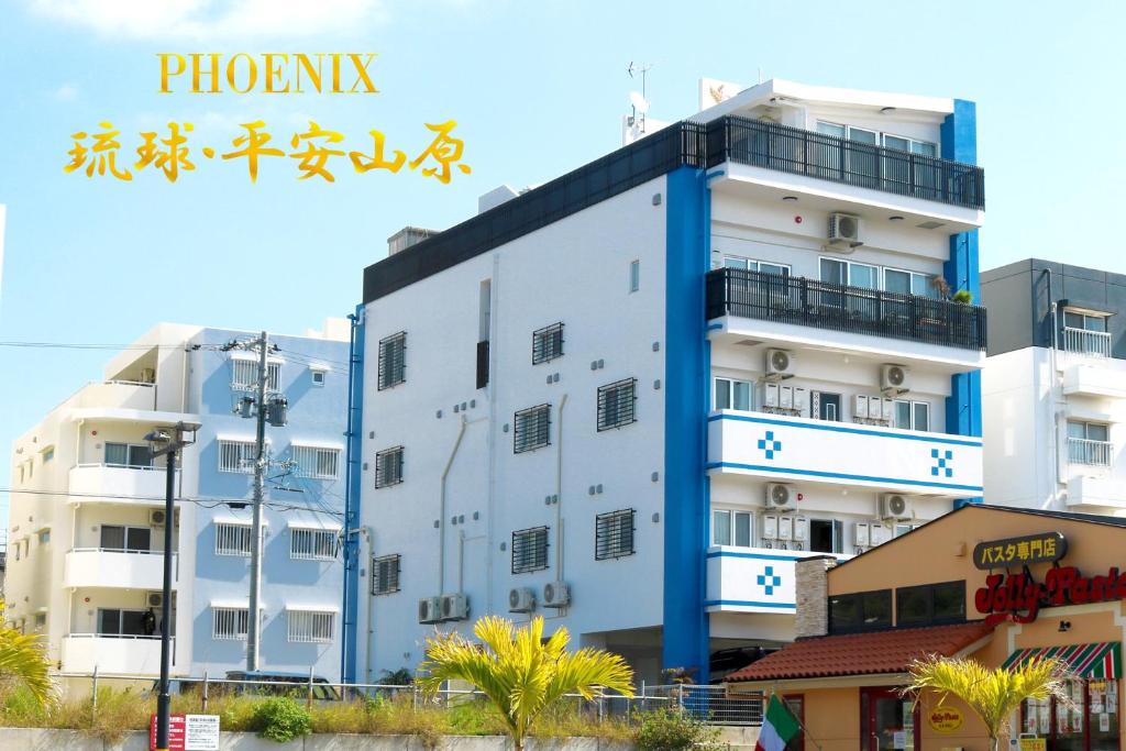 un edificio blanco con adornos azules junto a los edificios en Phoenix Ryukyu Henzanbaru -SEVEN Hotels and Resorts-, en Chatan