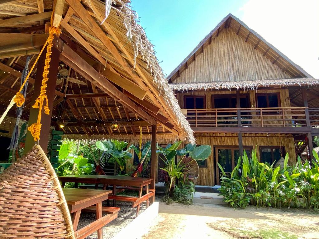 a wooden hut with a wooden table and chairs at Ilakai Hostel in General Luna