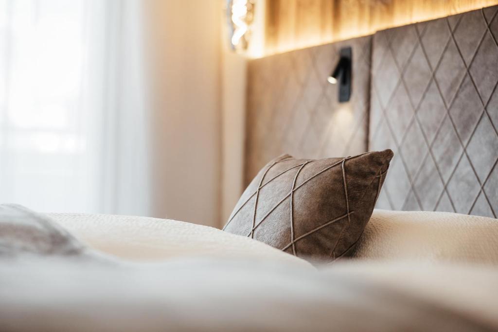 almohada marrón sobre la cama en Residence Villa Trieste en Corvara in Badia