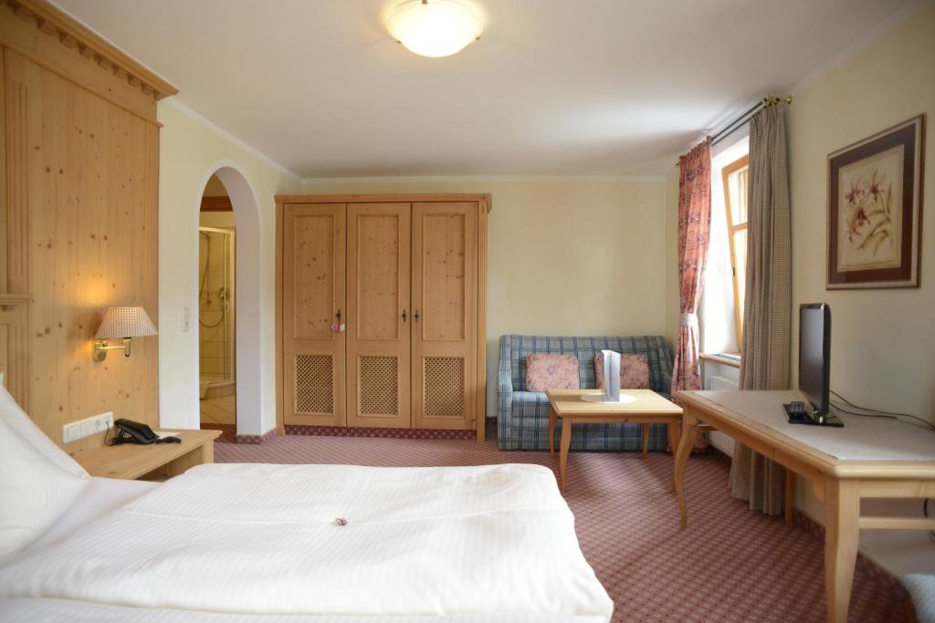 a hotel room with a bed and a desk at Alpengasthof zur Post in Schattwald