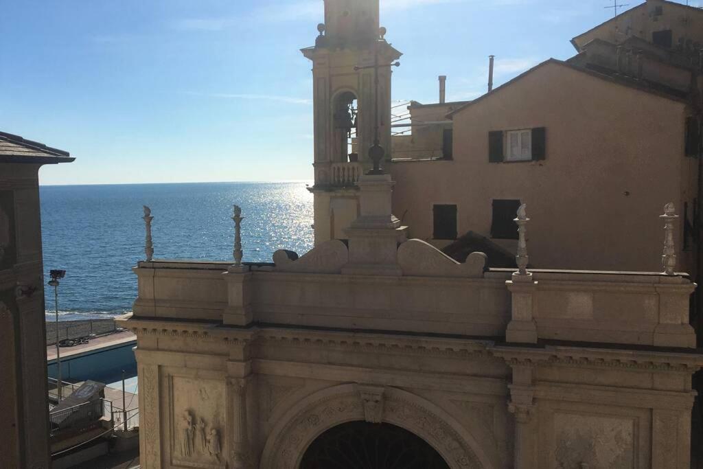 a building with a clock tower next to the ocean at la casa di Camilla in Sori
