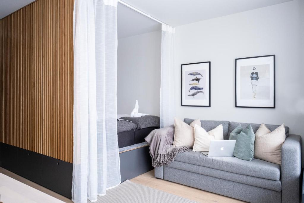 a living room with a couch and a laptop at HOOM Home & Hotel Järfälla in Järfälla