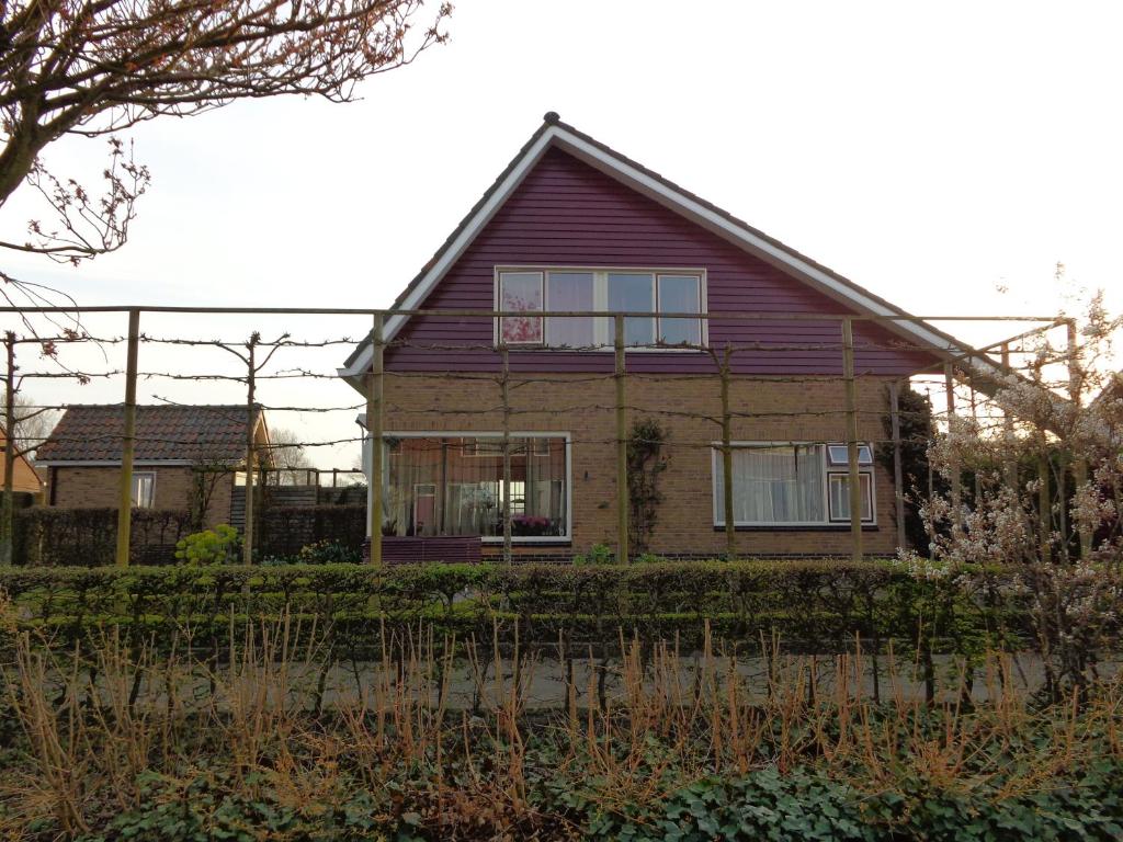 a house with a fence in front of it at Kamerverhuur Advenco in Aagtekerke