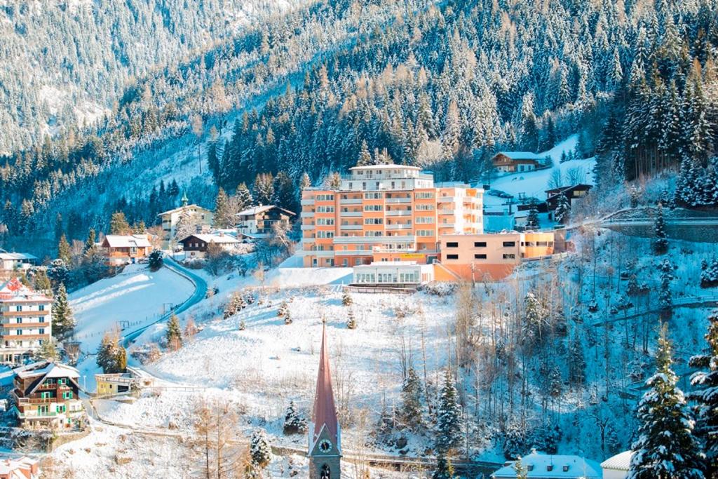 a town in the mountains with snow on the ground at Panorama SPA Aparthotel Schillerhof by AlpenTravel in Bad Gastein