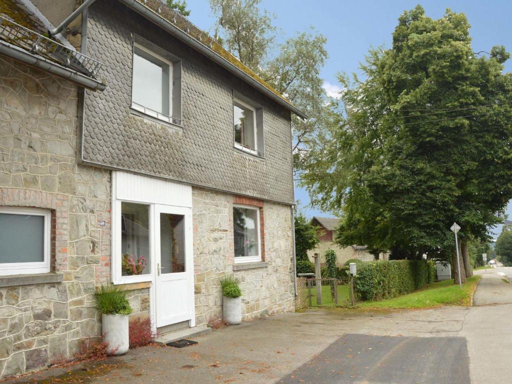 a brick house with a white door on a street at Holiday Home with Garden Heating Barbecue in Butgenbach