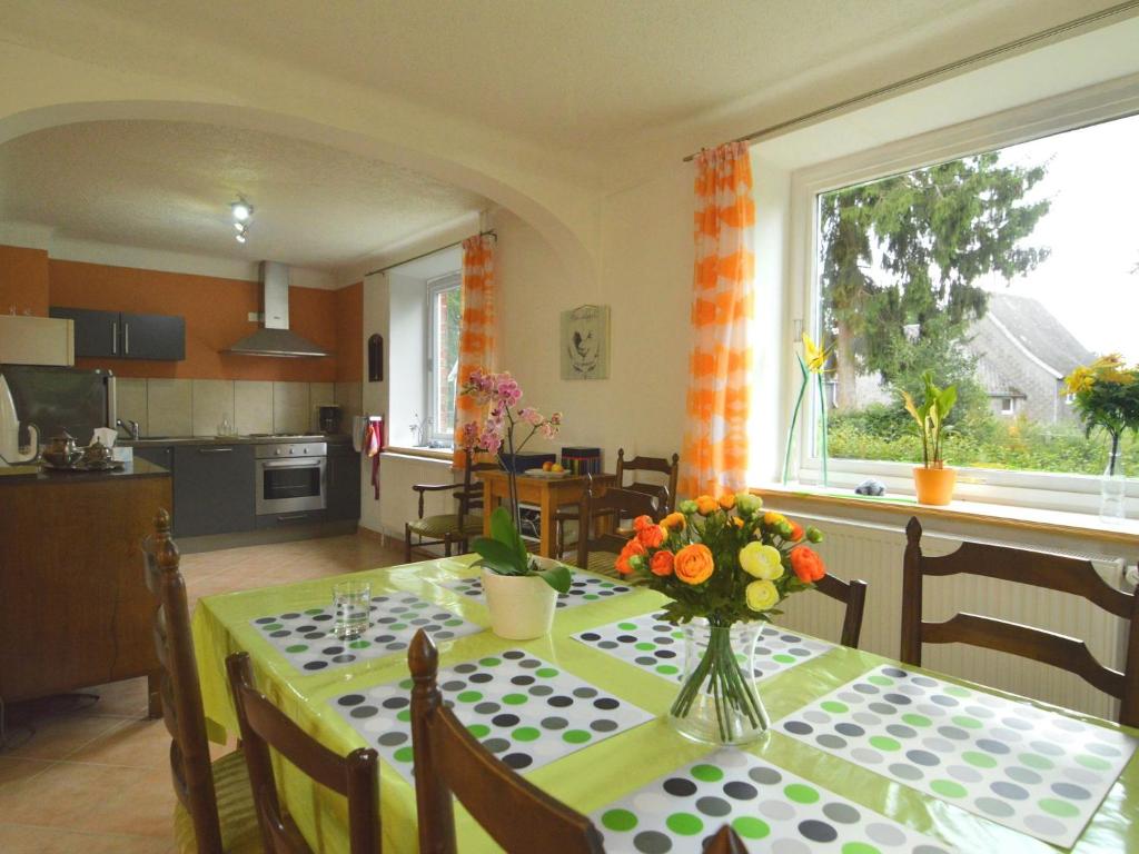 a kitchen and dining room with a table with flowers on it at Holiday Home with Garden Heating Barbecue in Butgenbach