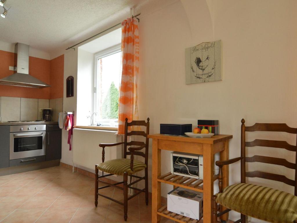 a kitchen with a table and chairs and a window at Holiday Home with Garden Heating Barbecue in Butgenbach