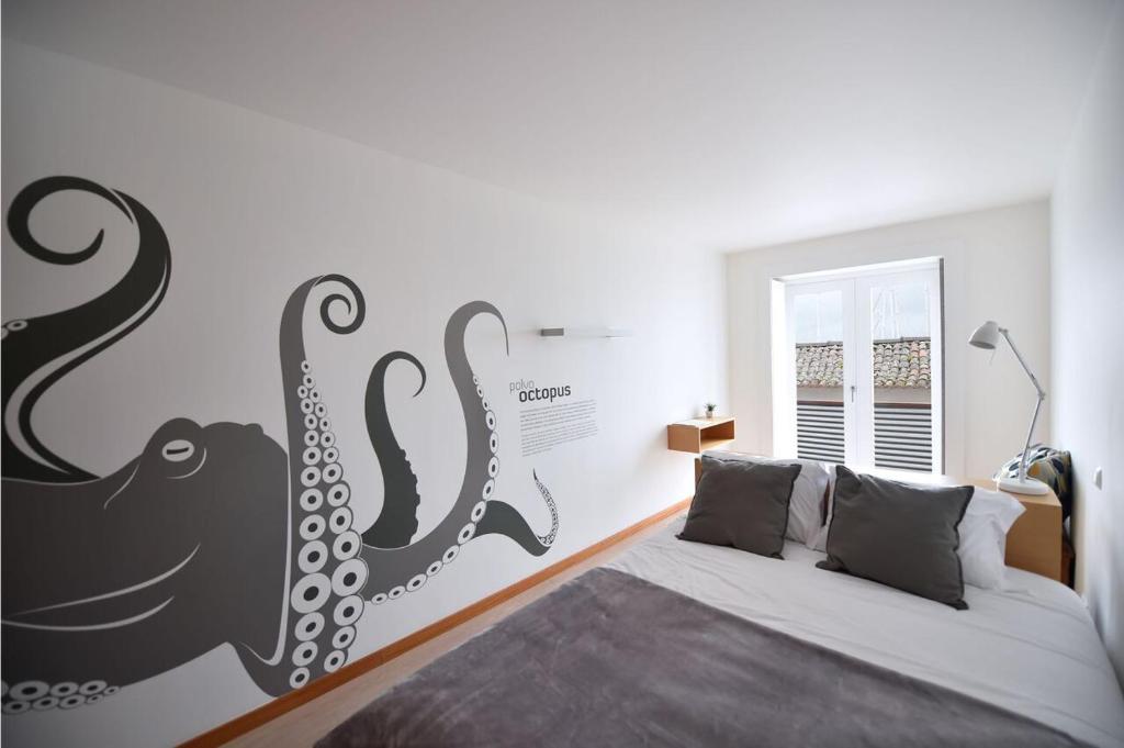 a bedroom with a bed with an octopus mural on the wall at Casa da Baía - Guest House in Horta