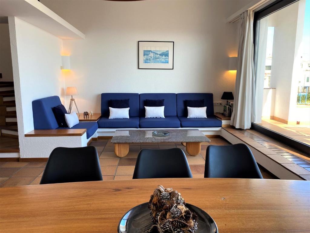 un soggiorno con divano blu e sedie di MATILLA - Apartamento con parquin a Cadaqués
