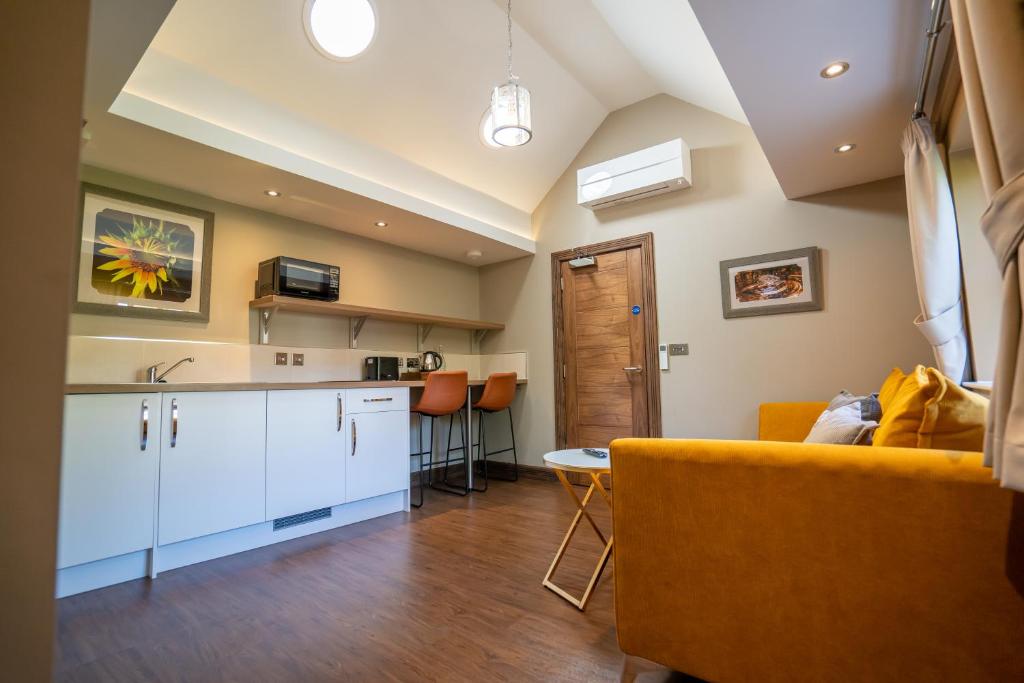 a kitchen and living room with a yellow couch at Bond Street Apartments in Wolverhampton