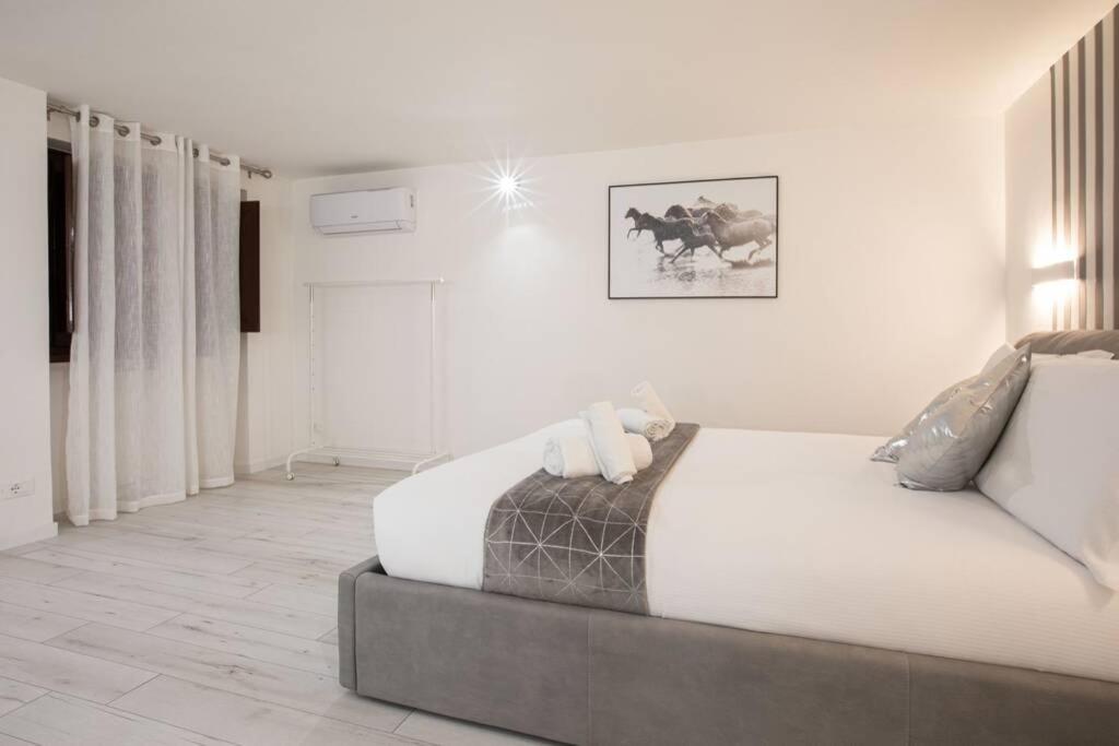 a bedroom with a large bed with white sheets at Unforgettable Split Level Jacuzzi Suite Navona - Top Collection in Rome