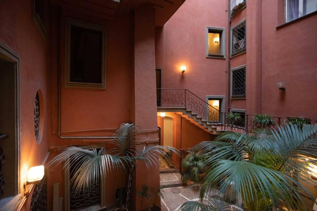 a building with stairs and palm trees in a courtyard at Unforgettable Split Level Jacuzzi Suite Navona - Top Collection in Rome