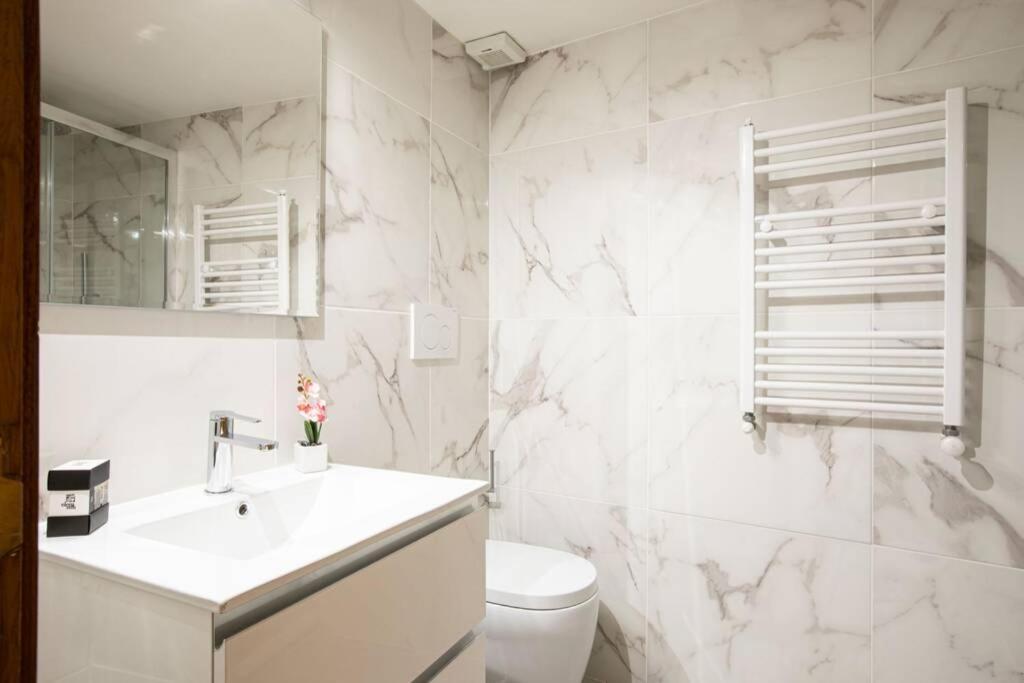 a white bathroom with a sink and a toilet at Unforgettable Split Level Jacuzzi Suite Navona - Top Collection in Rome
