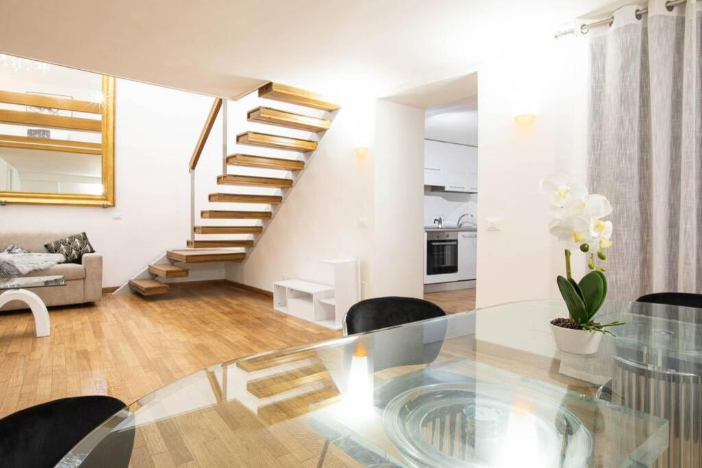a living room with a glass table and stairs at Unforgettable Split Level Jacuzzi Suite Navona - Top Collection in Rome