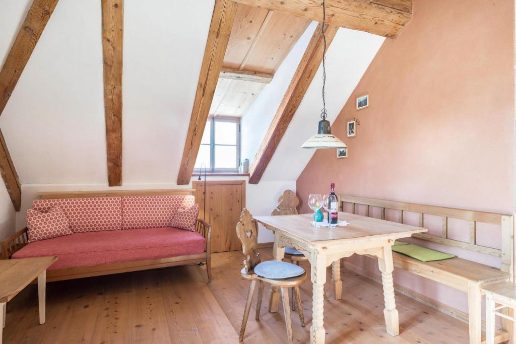 a living room with a table and a bench at Ferienwohnung Wachsbichl in Unterammergau