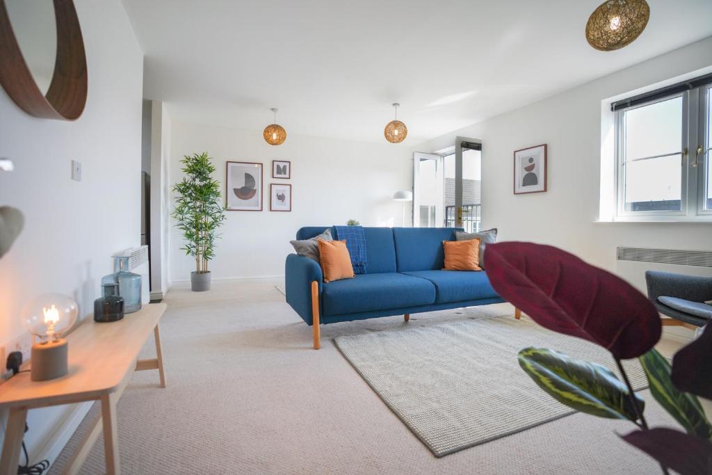 uma sala de estar com um sofá azul e uma mesa em Stylish Apartment with Private Parking em Cardiff