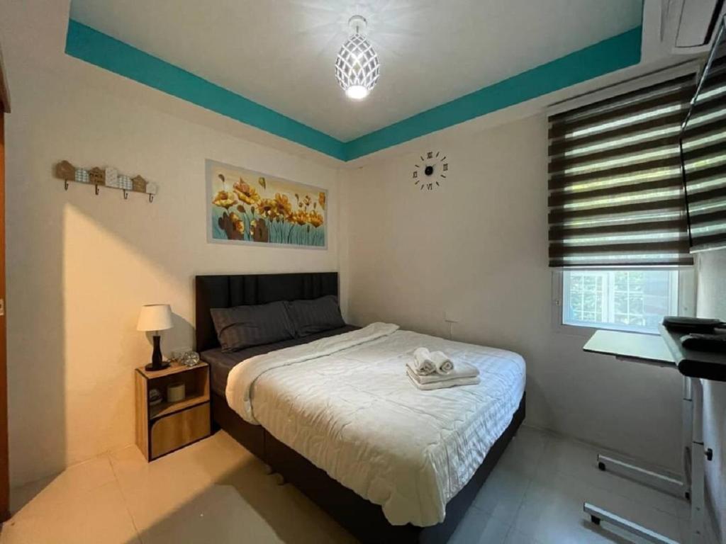 Un dormitorio con una cama y una lámpara y una ventana. en Great House 99, en Bangkok