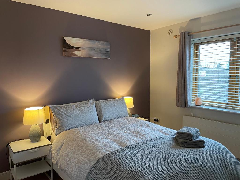 um quarto com uma cama, 2 candeeiros e uma janela em Boden Heath em Dublin